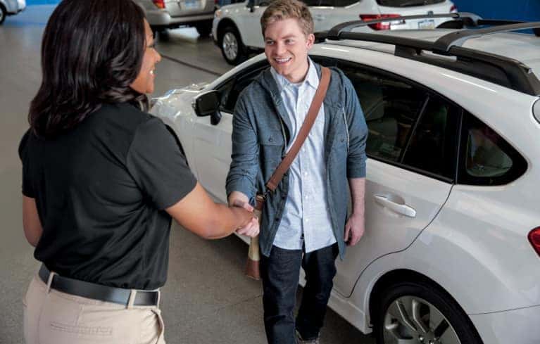 sales person greets young man in showroom