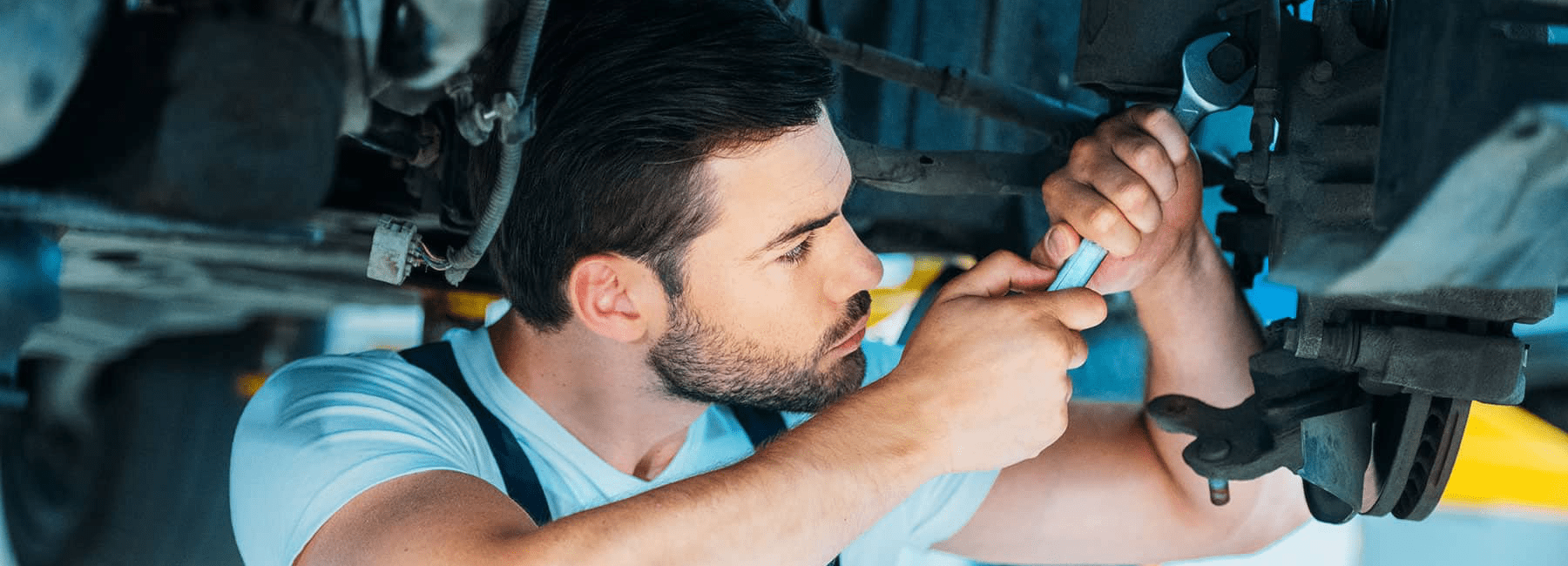 Mechanic Wearing Gloves with Tools working on engine