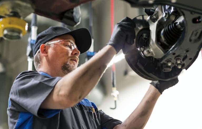 service technician installs new brakes