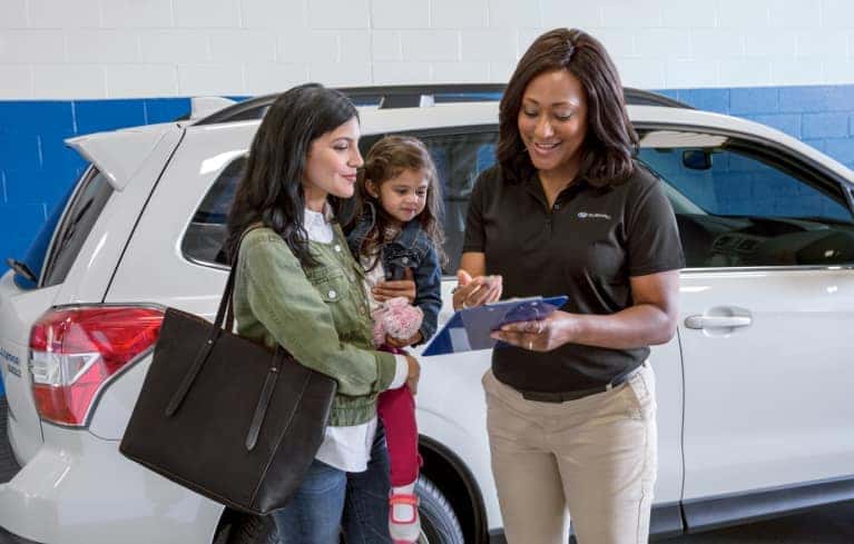 sales person greets woman and child in showroom