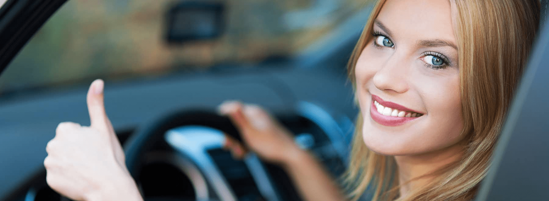 smiling-woman-gives-thumbs-up-in-new-car