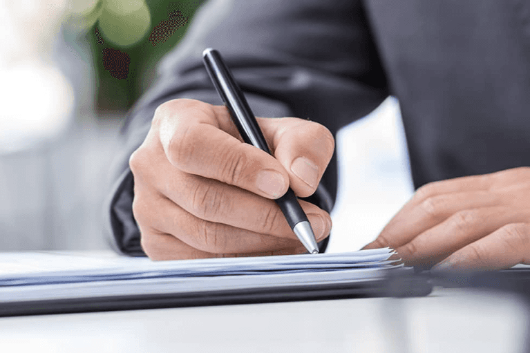 man signs papers in well lit room