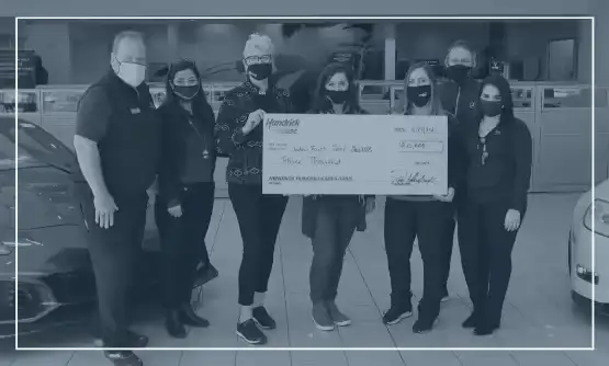 Hendrick employees holding donation check