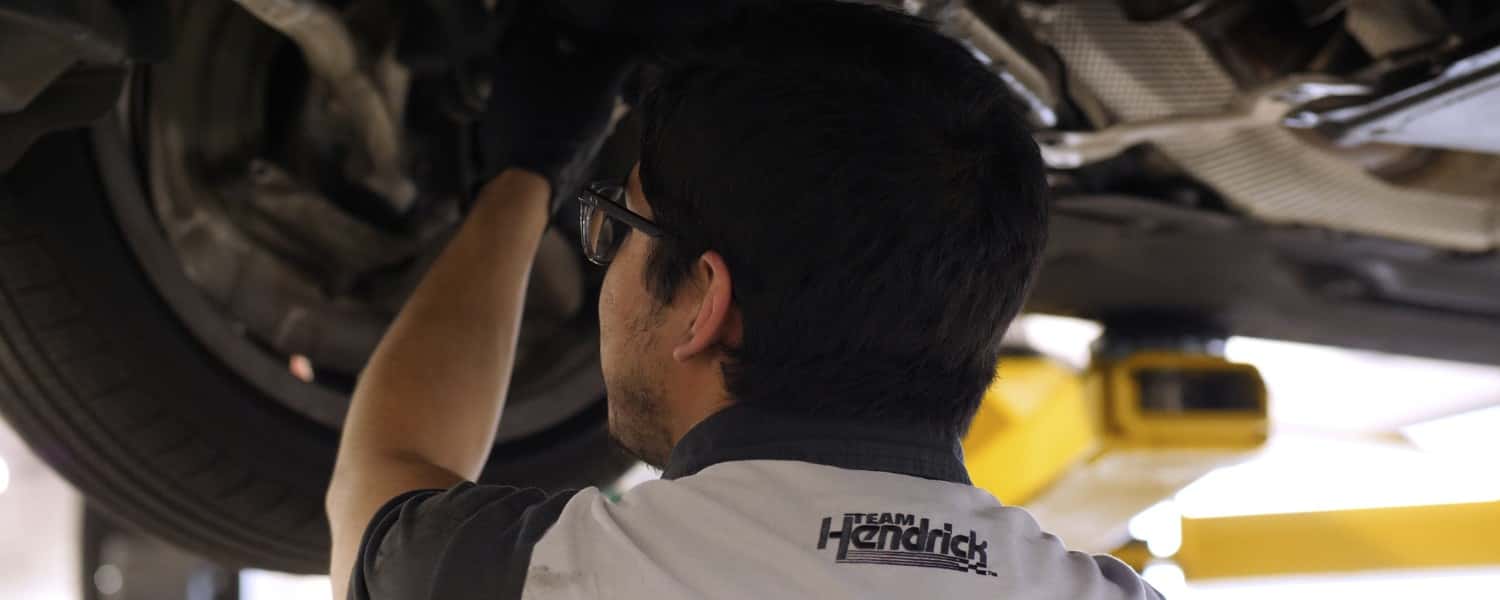 Car service mechanic working on automobile engine repair