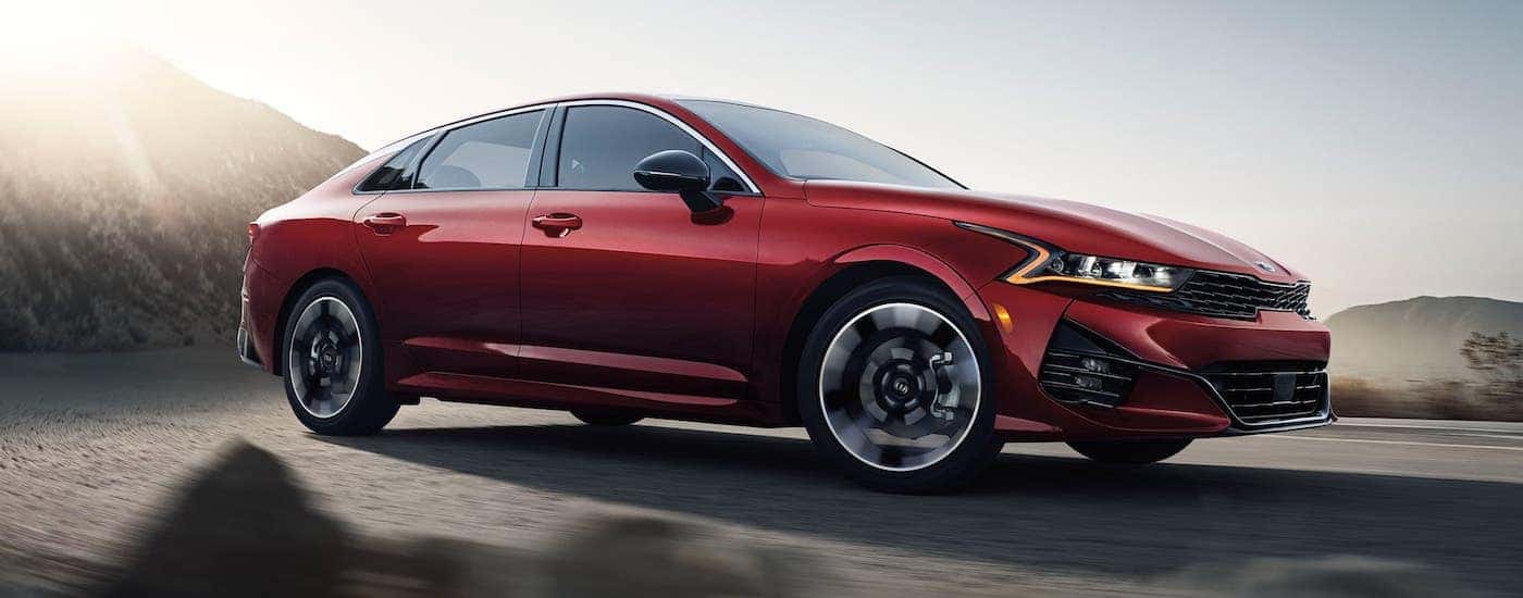 Red Kia sedan driving