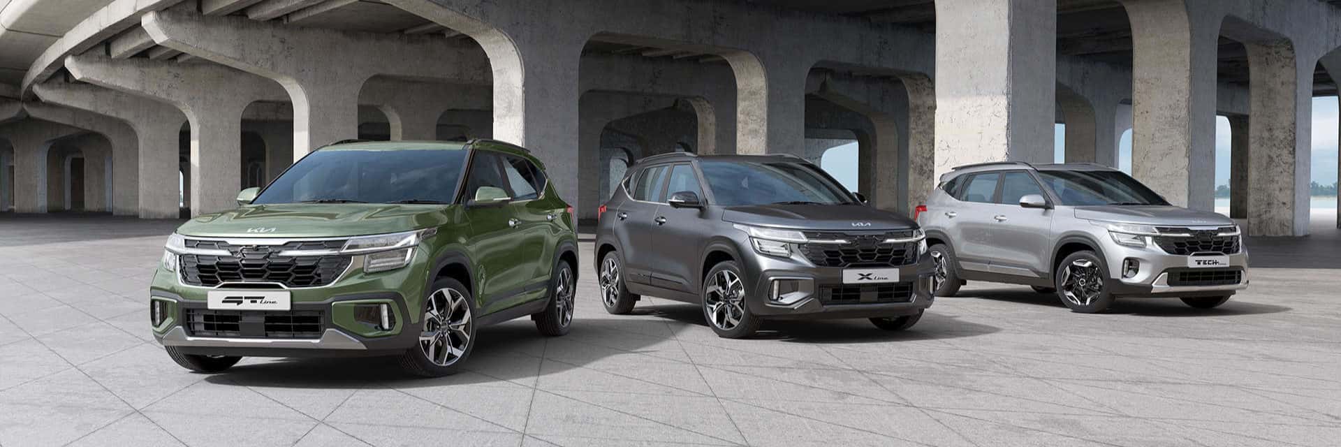 Three Kia Seltos parked under a bridge