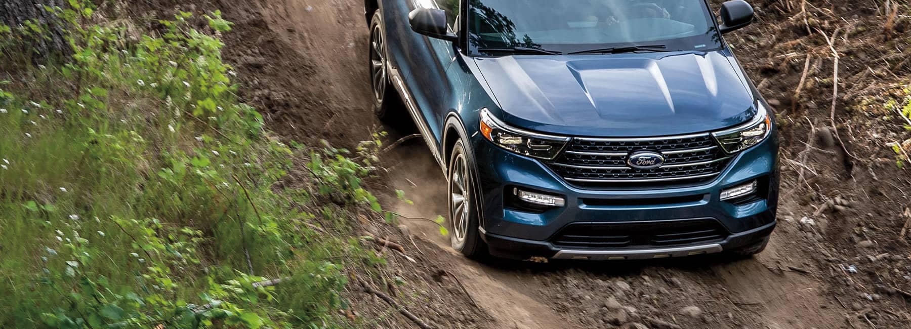 Atlas Blue 2022 Ford Explorer descending on a trail in the woods