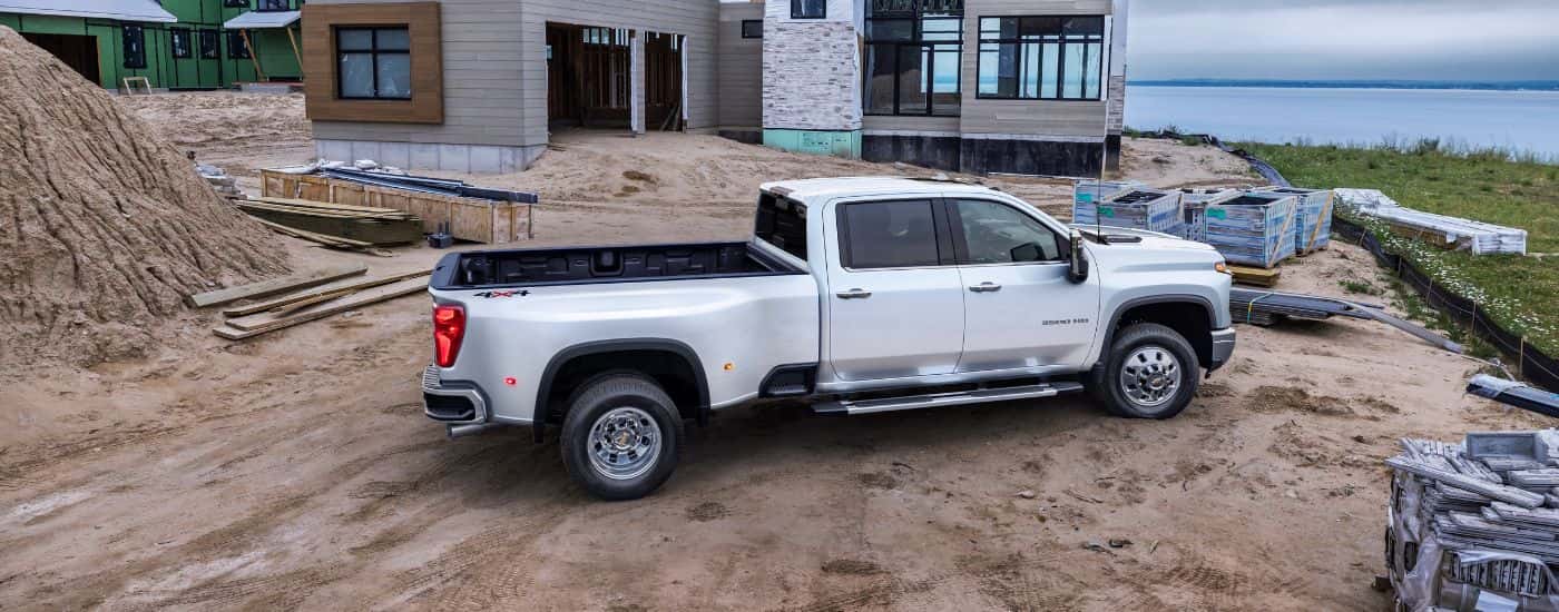 A white 2024 Chevy Silverado 3500HD LTZ is shown parked on a construction site.