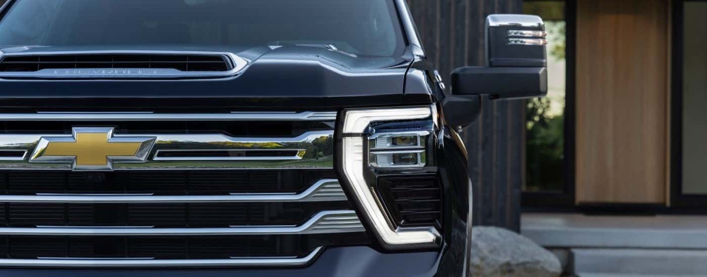 A close up of the grille on a black 2024 Chevy Silverado 2500 HD.
