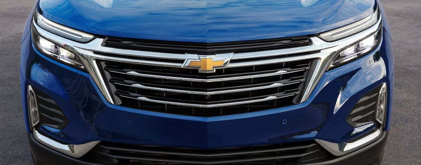 A close up of the grille on a blue 2022 Chevy Equinox Premier.