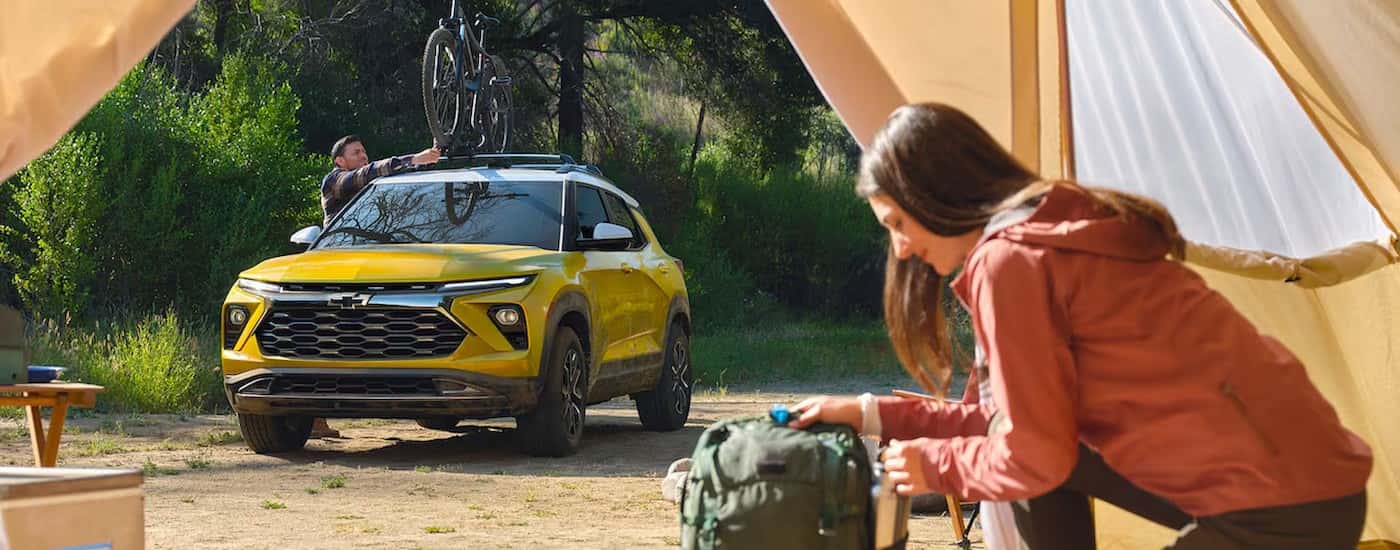 A yellow 2025 Chevy Trailblazer ACTIV is shown parked near a tent.