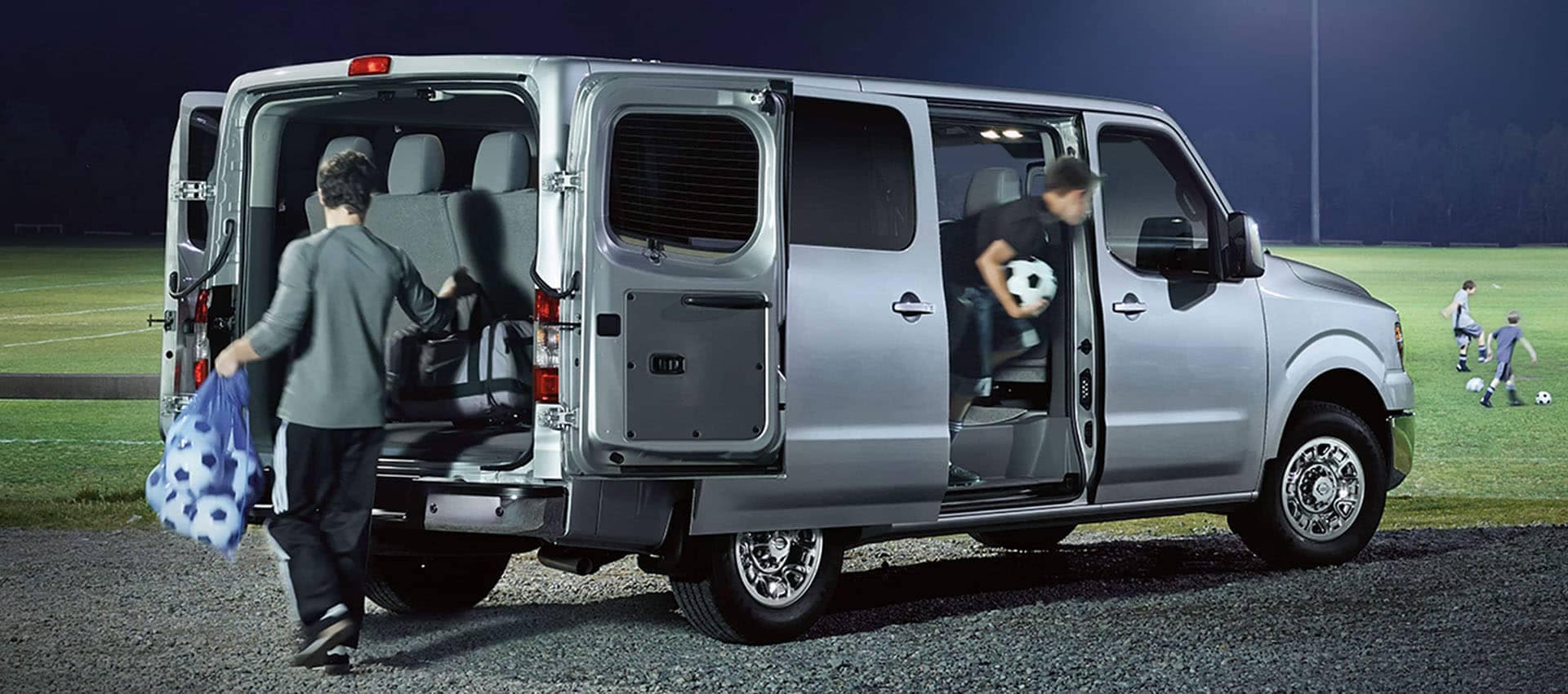 2019 Nissan NV Passenger with a teenager taking a bag of soccer balls out the back