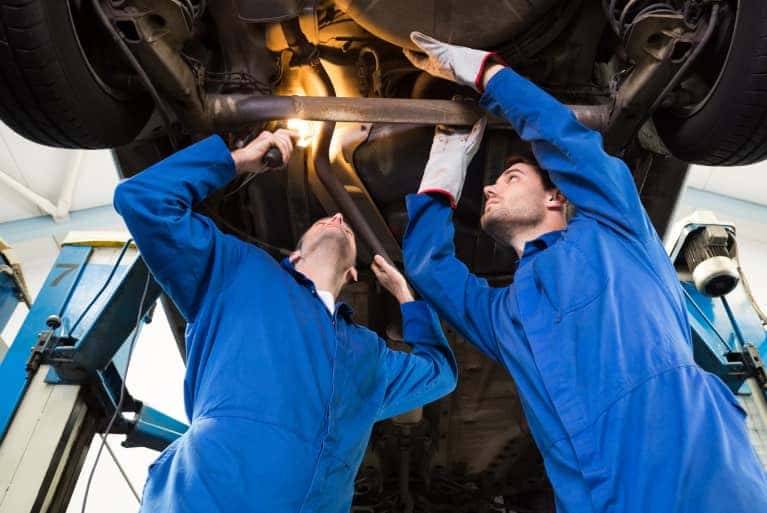 two service specialist looking at the undercarriage