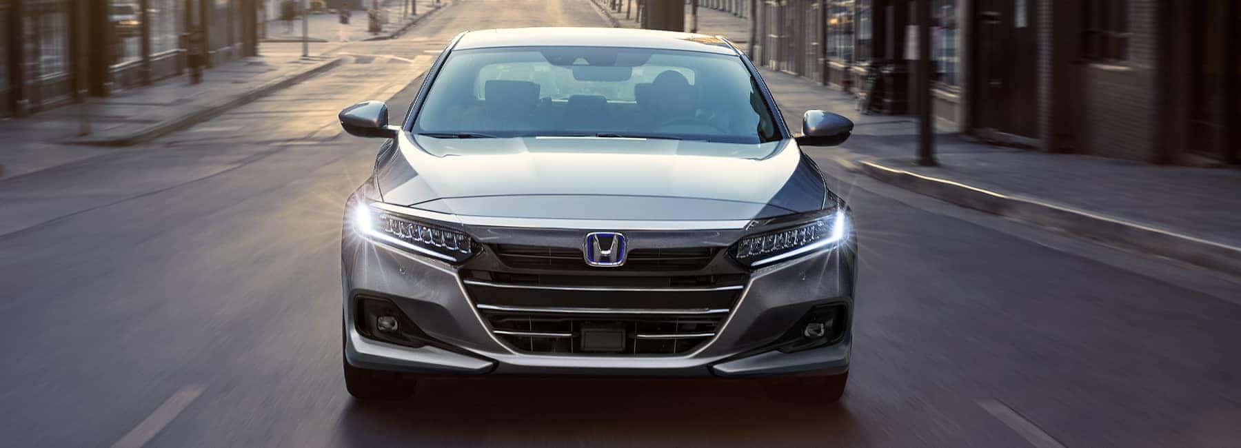 Front angle of a 2021 Silver Honda Accord driving up a city road