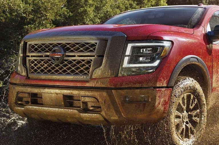 A 2021 Red Nissan Titan truck off roading in dirt_mobile
