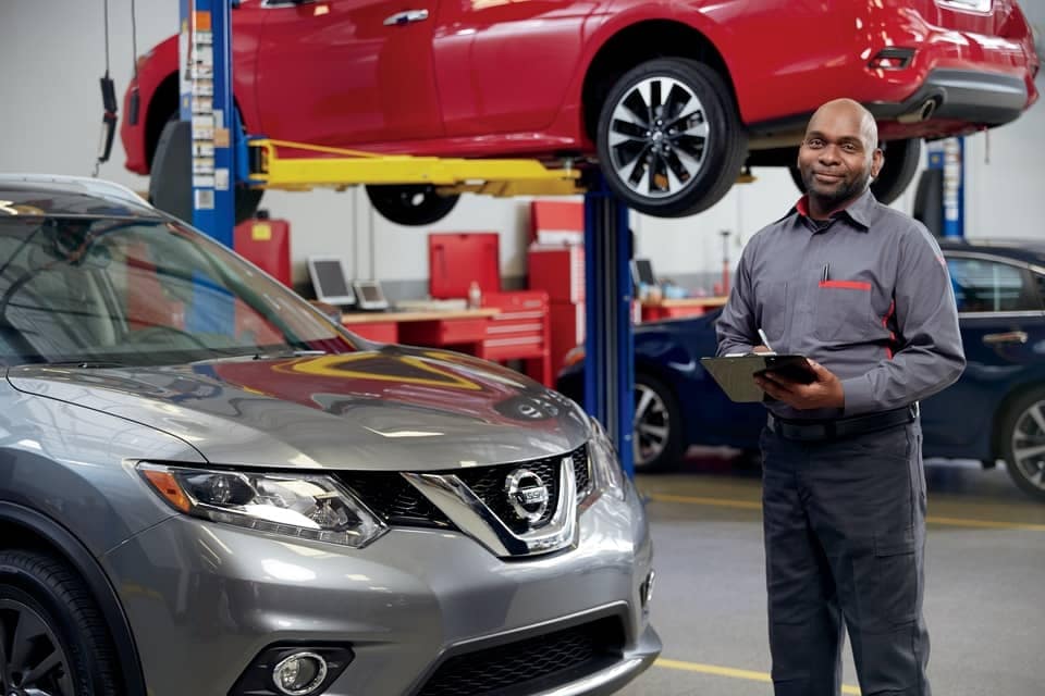 Nissan service technician looking over checklist