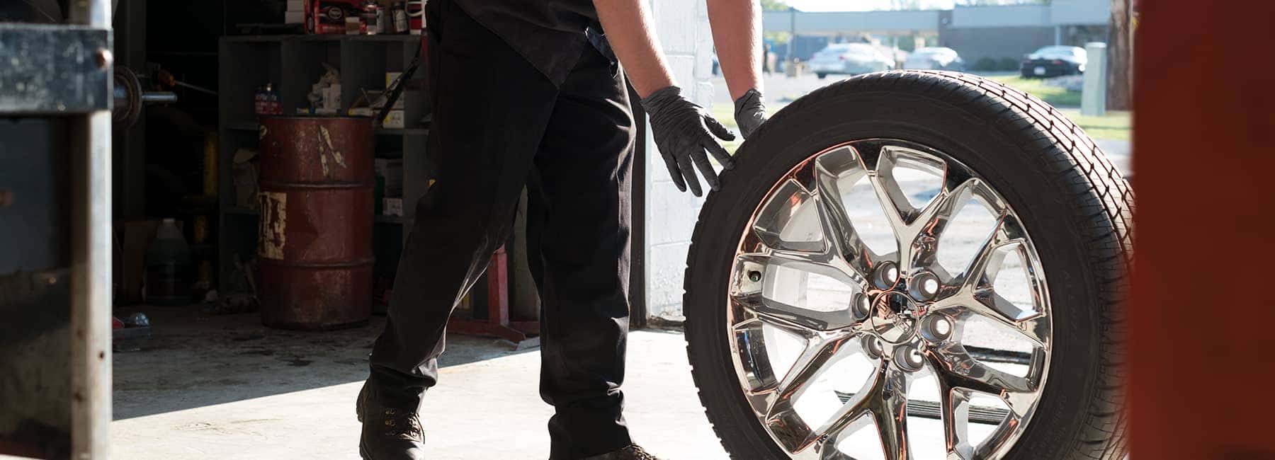 GM-service-technician-holding-car-wheel