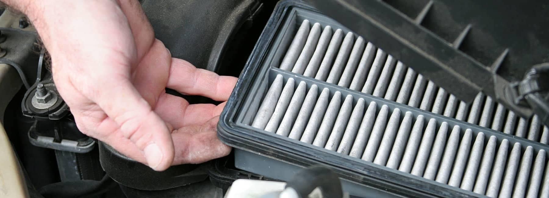 Hand Removing an Engine Air Filter