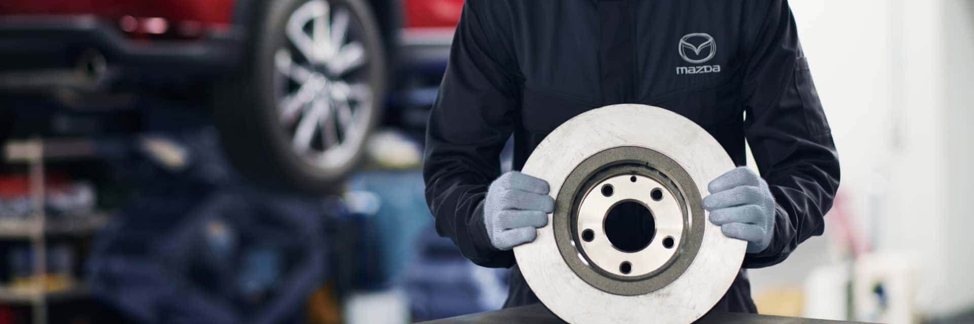 Mazda Service technician holding a brake rotor