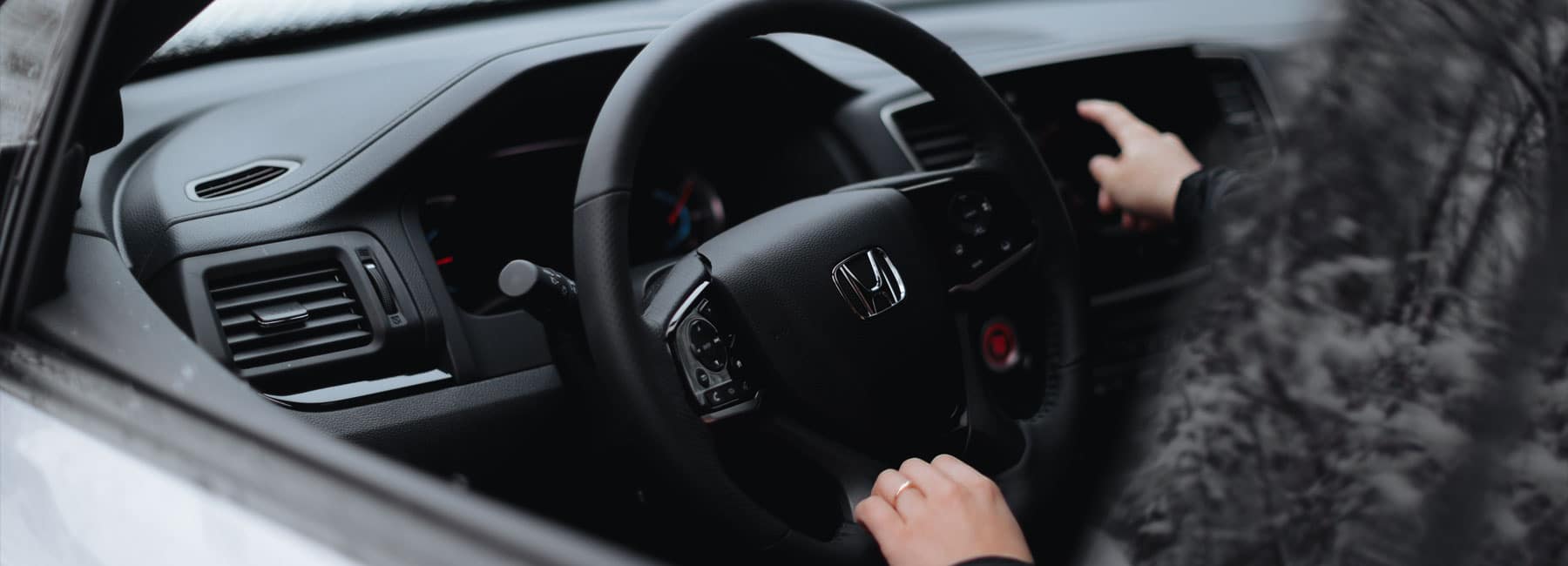 woman adjusts her radio in Honda car
