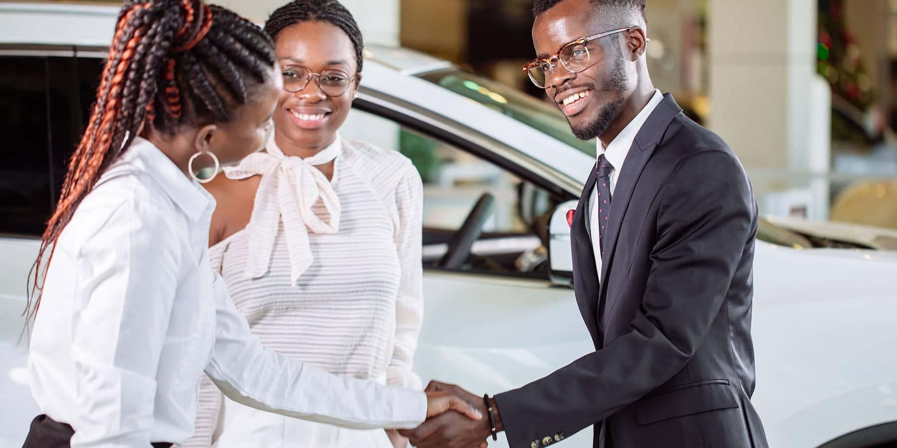 man and woman shaking hands with saleswoman