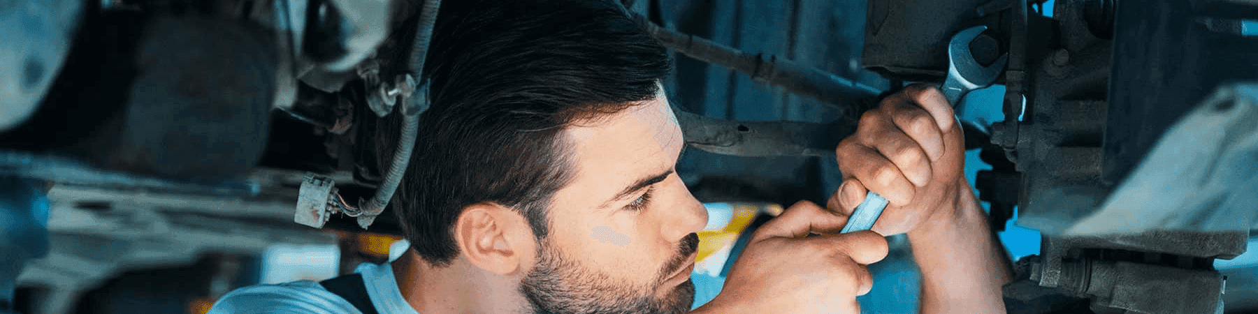 service man with wrench loosens bolt