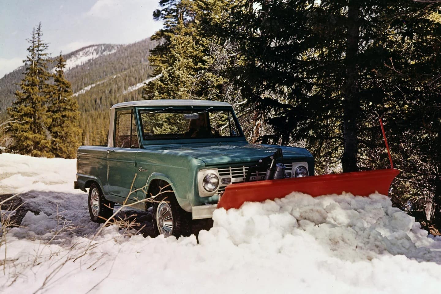 1967 Ford Bronco Pickup in Holly Green with a Wimbledon White roof and snowplow attachment.