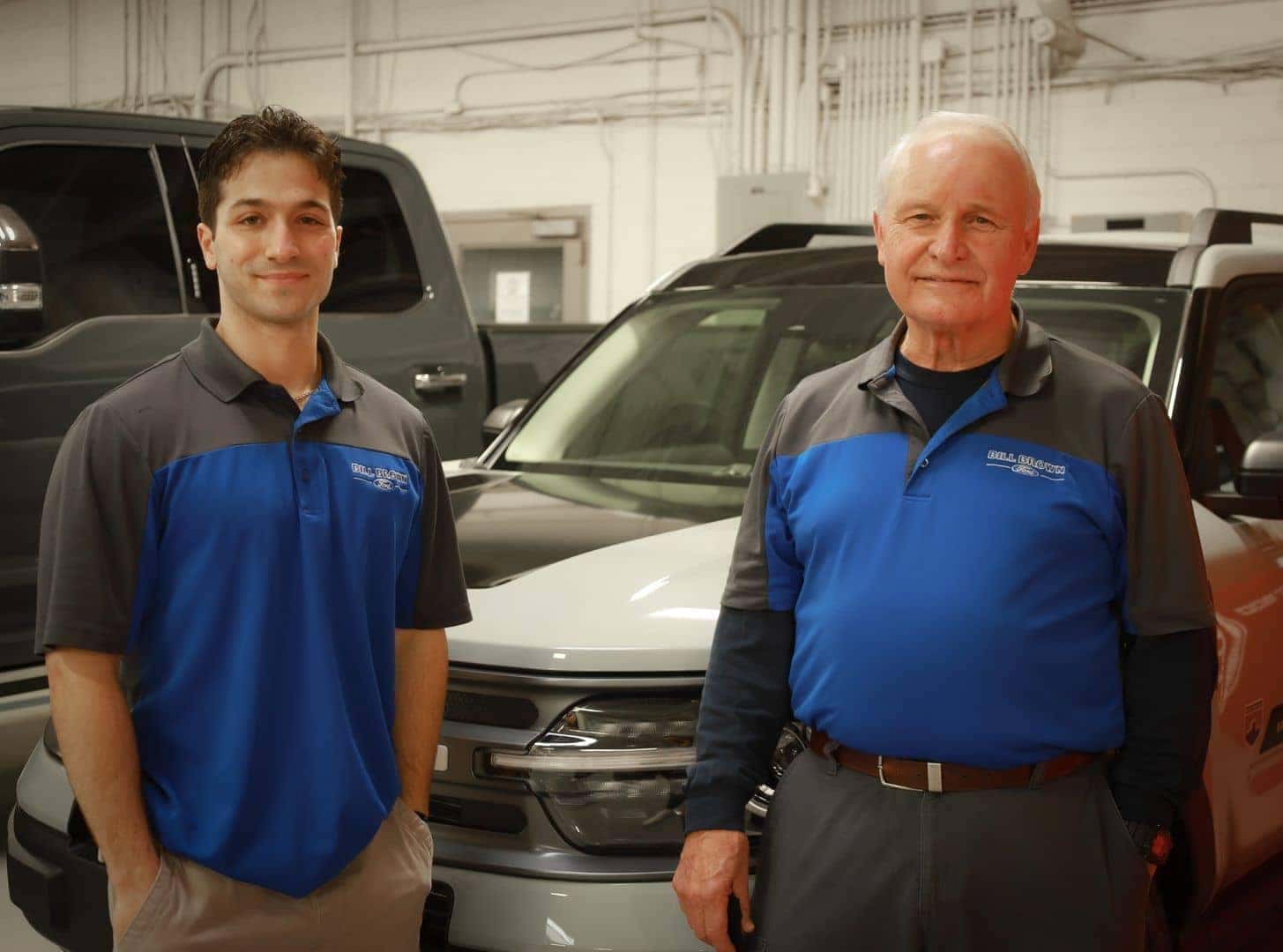 Two technicians in front of a vehicle