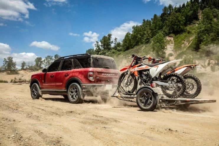 All-new Ford Bronco Sport Towing Dirtbikes through an off-road area.