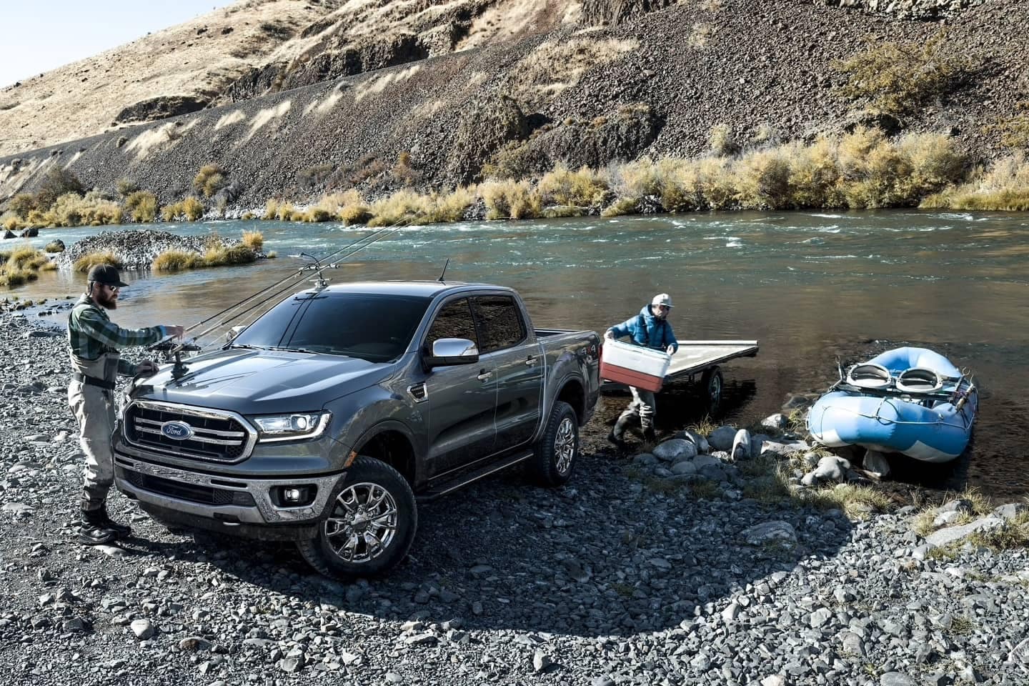 New Ford Ranger Lariat parked near a river with two fishermen and a raft.