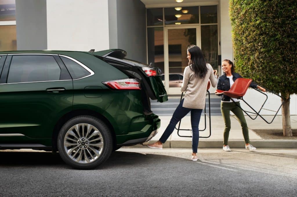 two women loading chairs in their 2022 Ford edge in Forest Green outside 