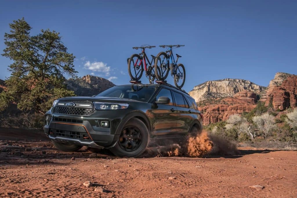 2022 Ford Explorer outfitted with bike rack on dirt road in the mountains 