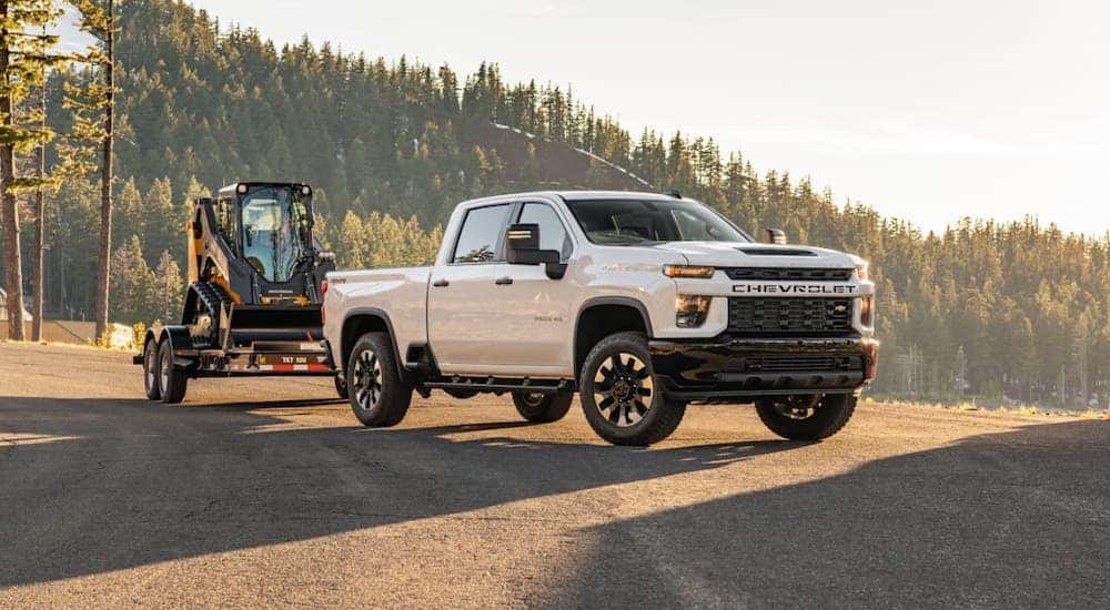 A white 2020 Chevy Silverado 2500HD is on an Indianapolis highway at sunset.