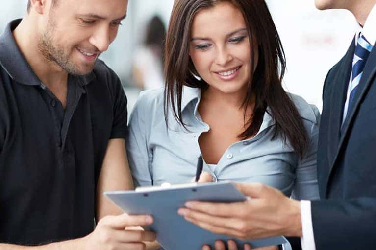 man and woman signing finance docs