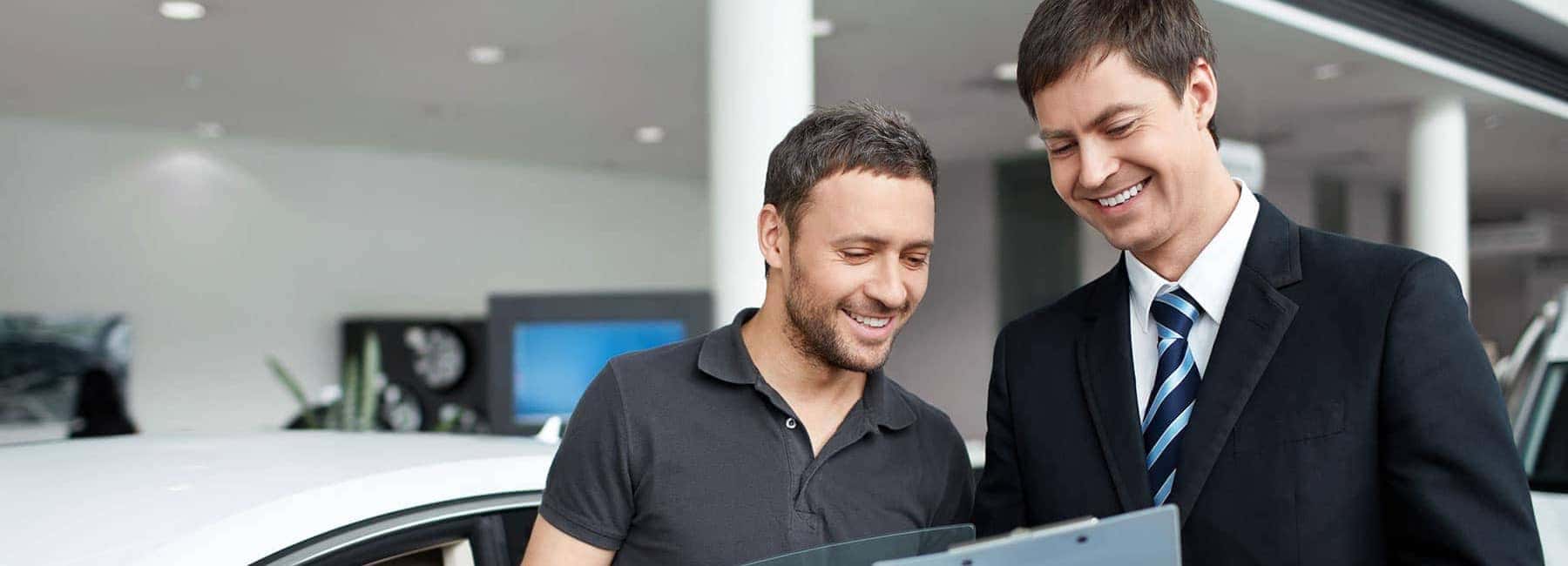 Man Looking at Documents with Dealer