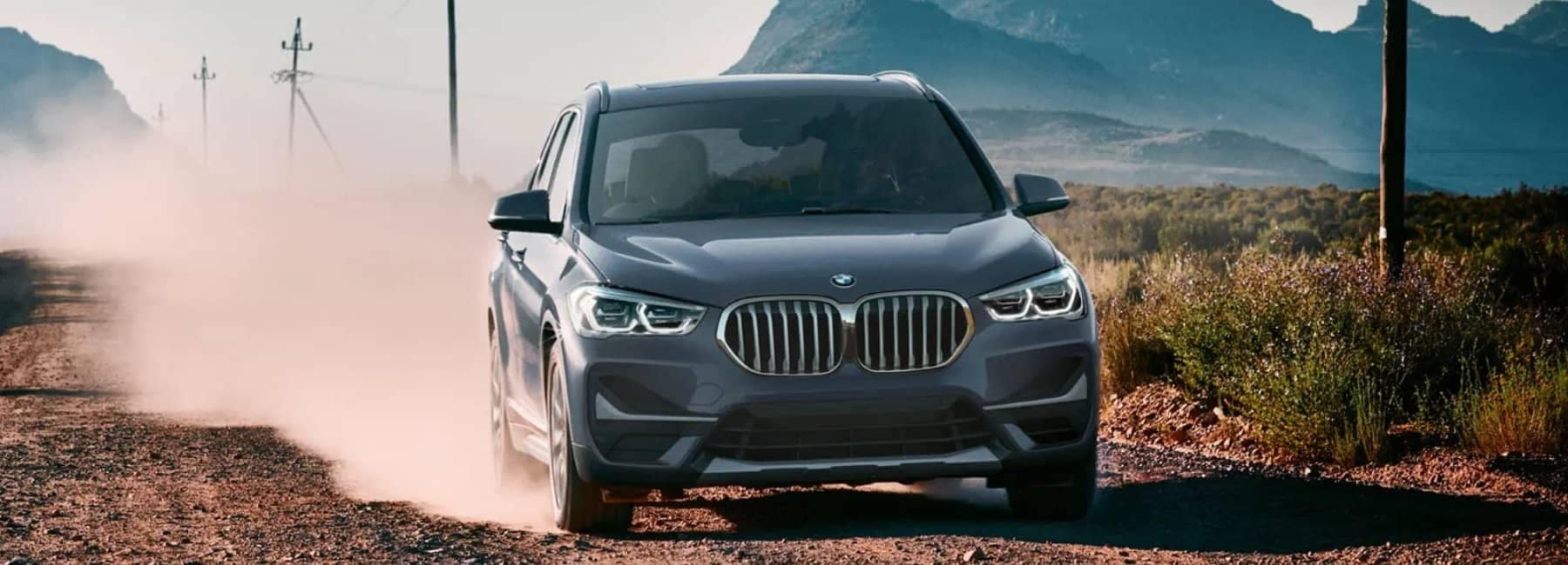 2022bmw-X1-dirtroad-frontview-grey