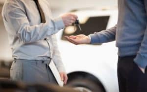 Man handing over car keys to customer