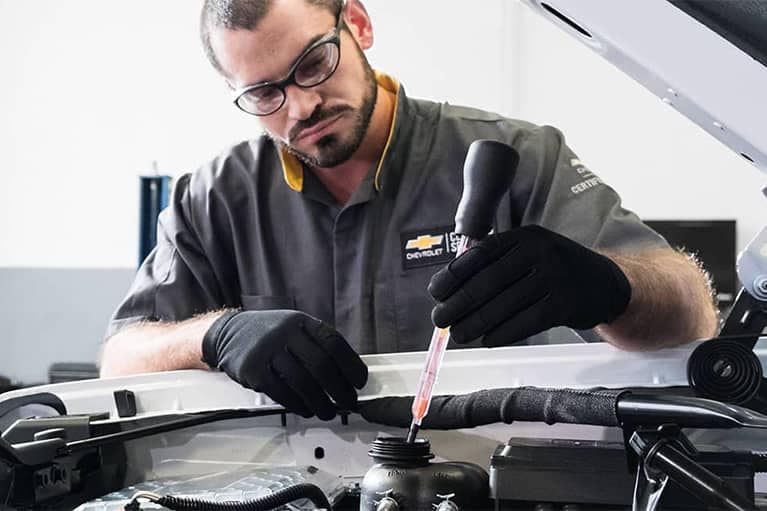 Chevrolet Service Technician looking at Cars Engine