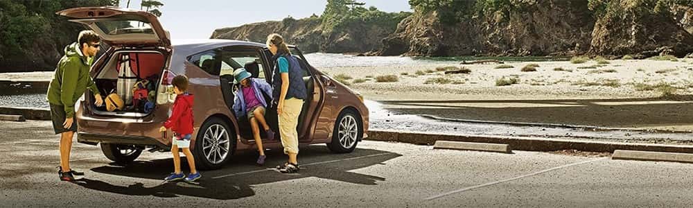 Family loading gear into 2018 Toyota Prius v, part of the Toyota Hybrid Lineup