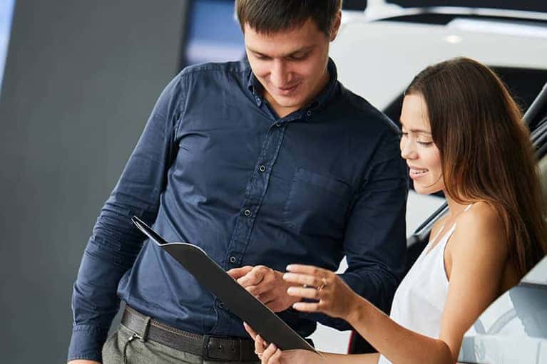 Happy-couple-reviewing-a-car-sales-contract