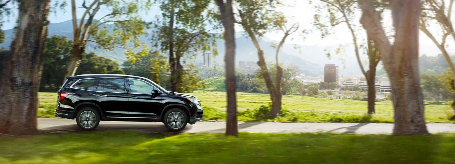 2021 Black Honda Pilot driving through a park