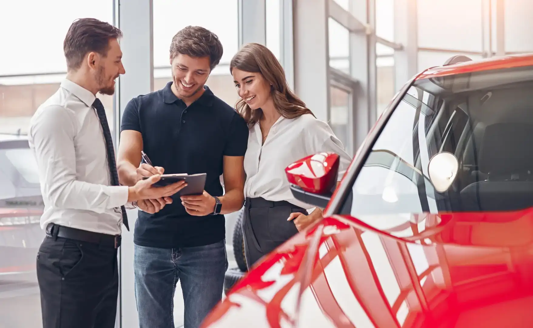 man and woman at a car dealership discussing car financing