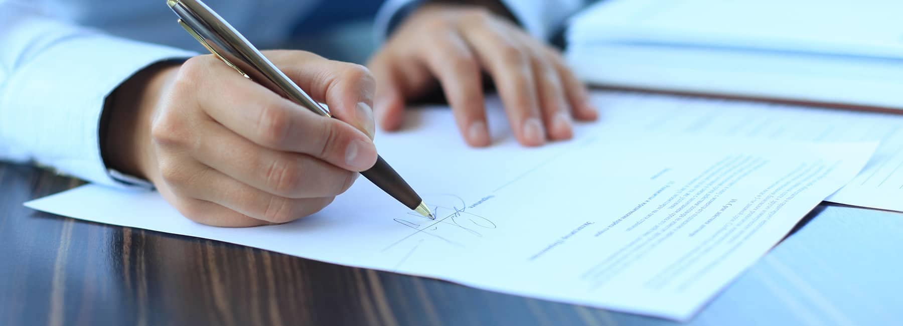 Sales rep signing paperwork at a car dealership