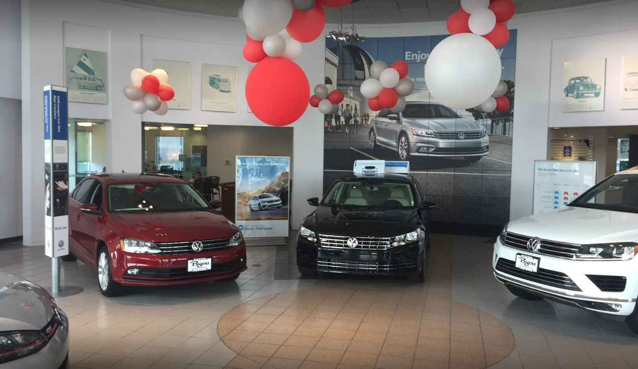 Photo of the showroom and three Volkswagen vehicles.