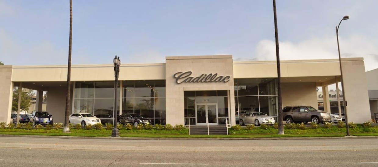 An exterior shot of a Cadillac dealership in the daytime.