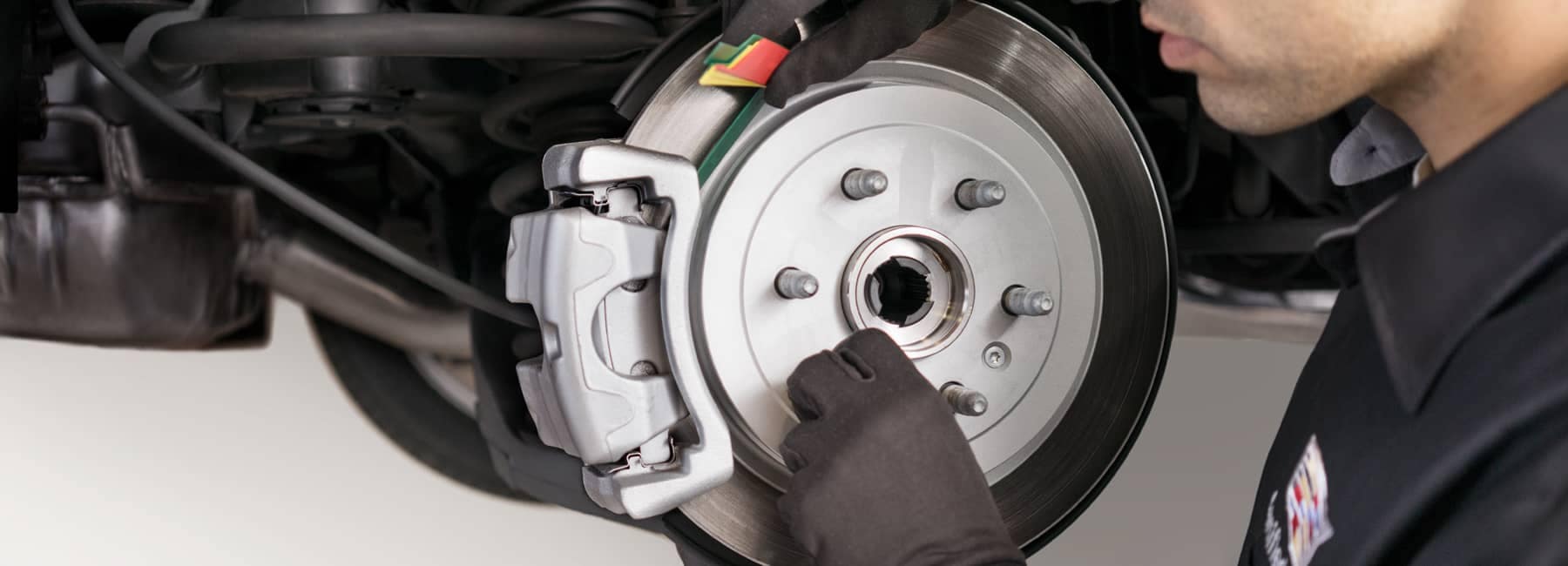 Cadillac service technician working on brakes