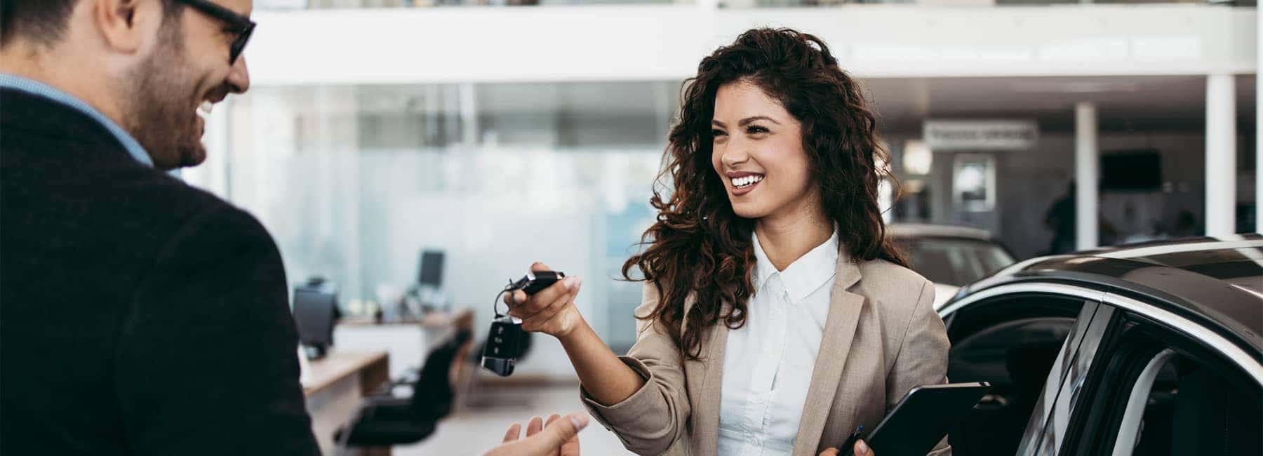 Handing off new car keys in a new car showroom
