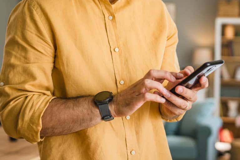 person-with-yellow-shirt-on-their-cell-phone