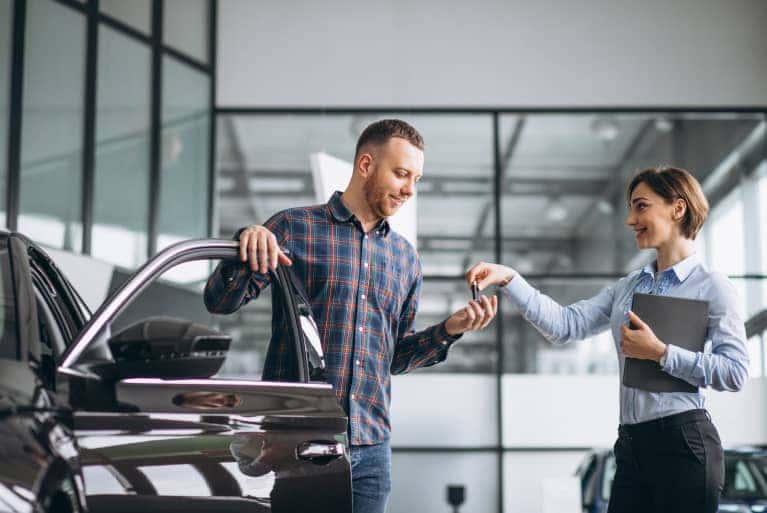 woman-handing-man-key-to-car