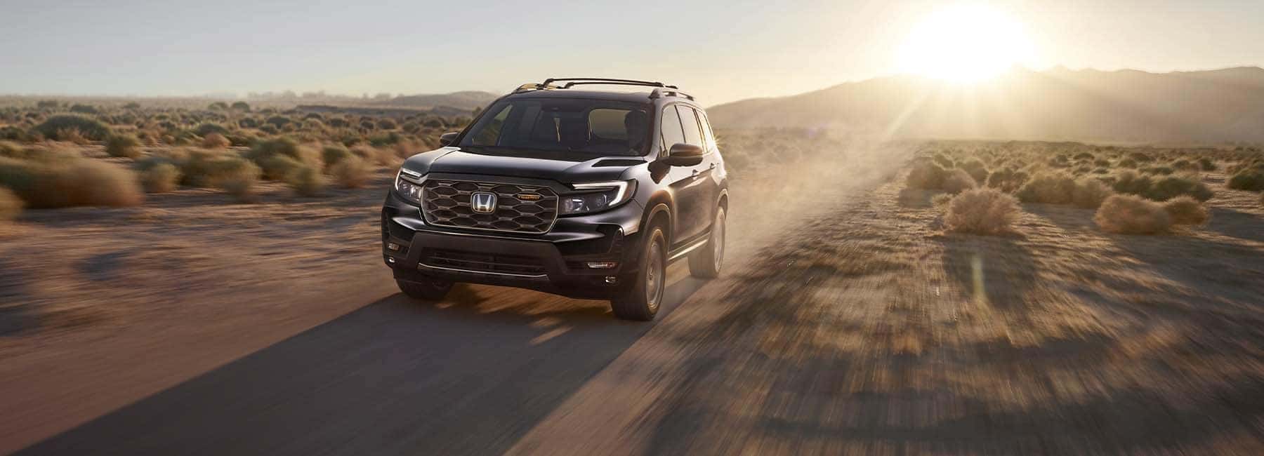 Black 2022 Honda Passport driving in the desert at sunrise